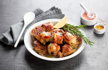 Roasted rabbit meat sliced with garlic, lemon and rosemary in a white plate