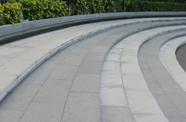 Staircase curved shape are finishing with gray granite tiles background.