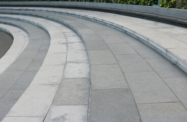 Stairway curved shape are finishing with gray granite tiles background.