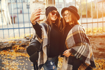 two young girls walk around the city in the autumn city and park