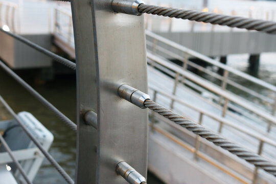 Stainless steel threaded stud joint with wire rope railing.