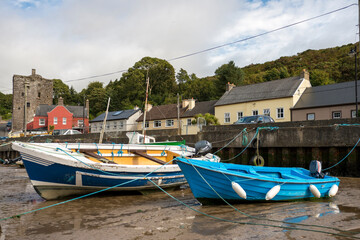 Wooden boats stranded on the sand of a southern Irish fishing port due to low tide