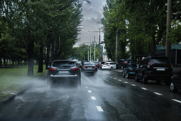 View of city road with cars on rainy day