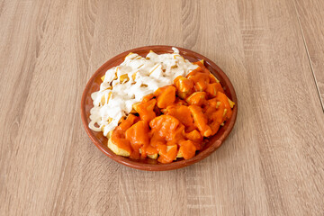 Spanish mixed tapa of fried potatoes with brava sauce and the other half with mayonnaise sauce
