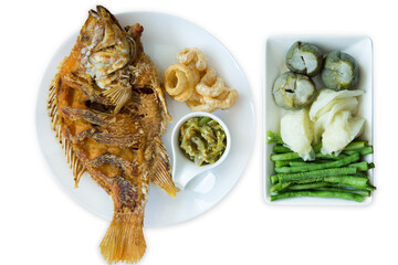 Top view fried tilapia fish and Thai Green Chilli Dip with blanched vegetables, focus selective.