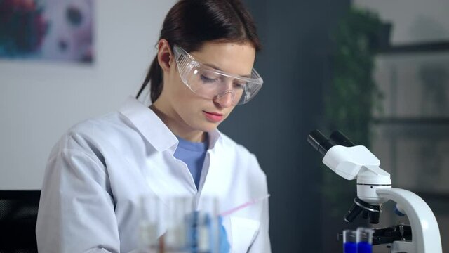 woman microbiologist student is examining samples in laboratory