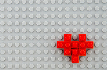 minimalistic concept of medicine and human rights, heart made of red children's constructor, on a gray background,