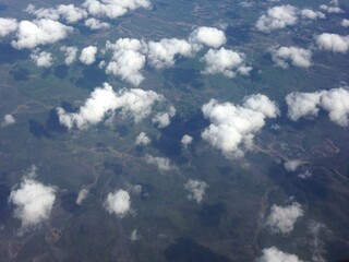 Under the wing in sky between clouds.