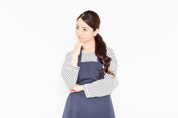困っているエプロン姿の女性