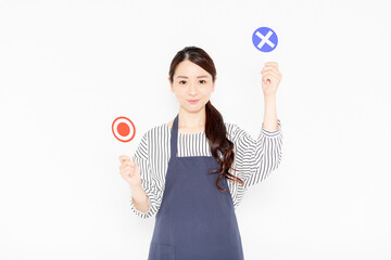 NGのプラカードを持っているエプロン姿の女性