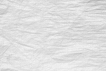 Fototapeta na wymiar The texture of an uneven crumpled artificial fabric. Abstract white background for wallpaper, design