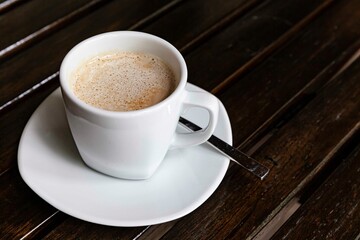 The coffee mug placed on the wood table top