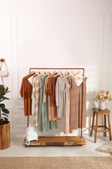 Stylish clothes hanging on rack in dressing room. Interior design