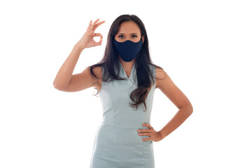 Flu epidemic, dust allergy, protection against virus concept- studio portrait of young asian woman wearing a face mask and showing ok sign with fingers, isolated on white background