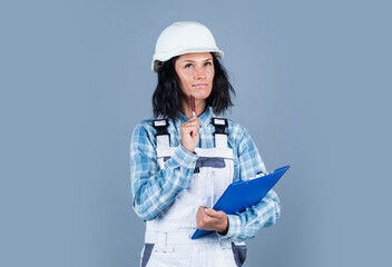 Your one stop source. mechanic girl in protective hardhat. building and construction. professional manual worker. technician working folder planning documents. safety uniform