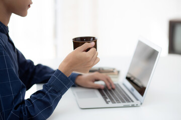 Young business man working from home with laptop computer on desk, freelance male sitting stay home using notebook for communication and relax on table, entrepreneur in startup business, new normal.