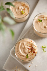 mousse dessert with nutella, chocolate paste, cheese and cream with nuts on the table and on the board