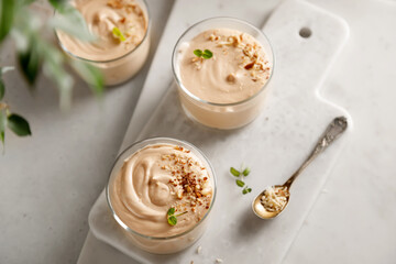mousse dessert with nutella, chocolate paste, cheese and cream with nuts on the table and on the board