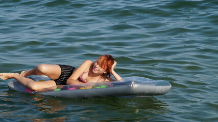 teenage girl lying on an inflatable mattress in the water