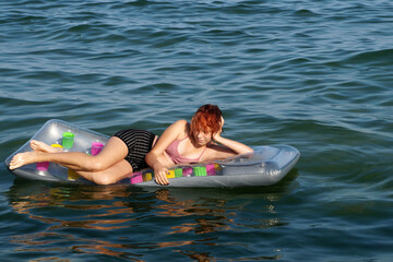 teenage girl lying on an inflatable mattress in the water