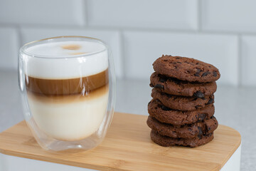 Thermo coffee mug on a bamboo tray and lots of chocolate chip cookies.