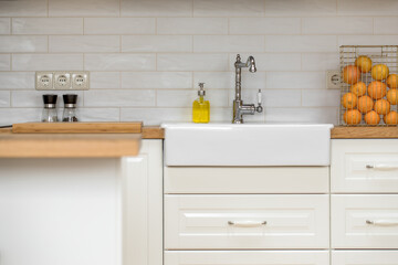 Close-up of white wooden facade of a traditional white style kitchen with metro tiles and solid wood worktop