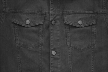 part of a jacket made of coarse black cotton fabric with pockets and buttons for a background or for a close-up wallpaper