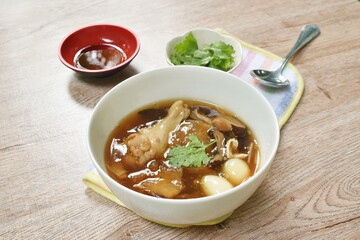 braised fish maw with bamboo shoot topping slice chicken and boiled egg quill in red gravy soup on bowl