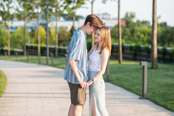 Couple of teenagers holding hands and hugging in the park. The first love