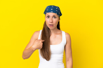 Young English woman isolated on yellow background pointing to oneself