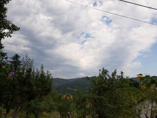 Genova, Italy - July 25, 2021: Beautiful view from the window to a small village's  landscape in summer days with grey sky in the background.