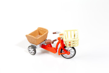 red tricycle with basket on white background