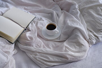 A cup of black coffee in bed. Interior. Cosiness.