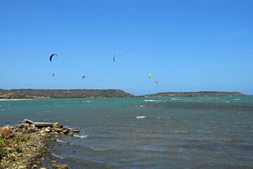 Group of kiteboarders surfing across the water at Sint Joris Baai on the island of Curacao