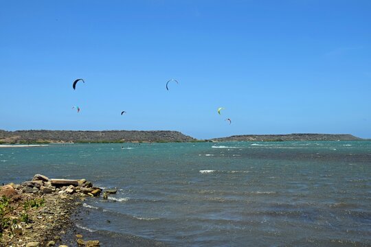 Group of kiteboarders surfing across the water at Sint Joris Baai on the island of Curacao