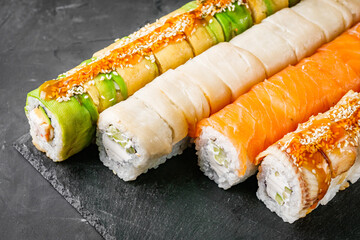 appetizing set of sushi roll on a black stone plate