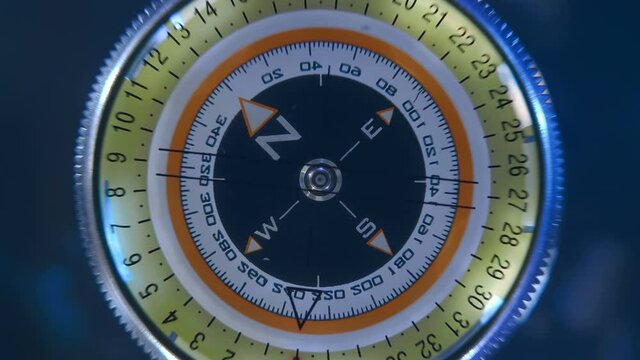 Compass with a rotating arrow on a black background, as a device for orientation on the ground and a symbol of travel around the world and geographic discoveries. Closeup