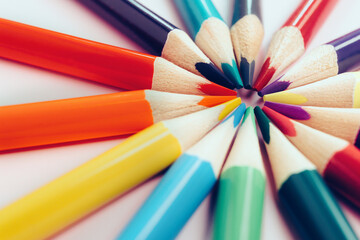 Fototapeta premium A figure of colored pencils in the shape of the sun with rays. The concept of creativity or development of the group. Abstract background. minimalism.