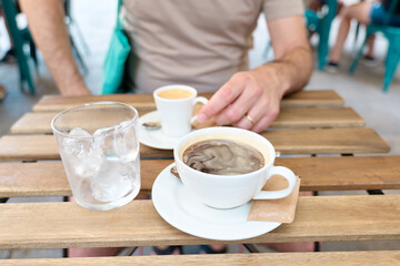 Fototapeta na wymiar Cup of coffee on a table bar outside