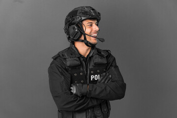 SWAT caucasian man isolated on grey background happy and smiling