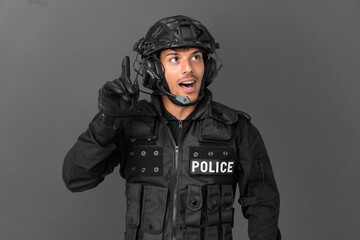 SWAT caucasian man isolated on grey background intending to realizes the solution while lifting a finger up