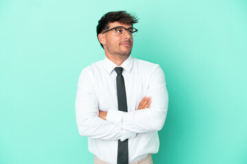 Business caucasian man isolated on blue background making doubts gesture while lifting the shoulders