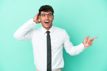 Business caucasian man isolated on blue background surprised and pointing finger to the side