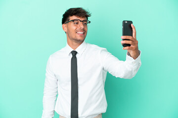 Business caucasian man isolated on blue background making a selfie