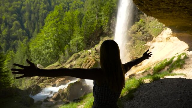silhouette of a woman at a waterfall