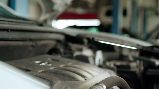 Mechanic inspects engine with a flashlight