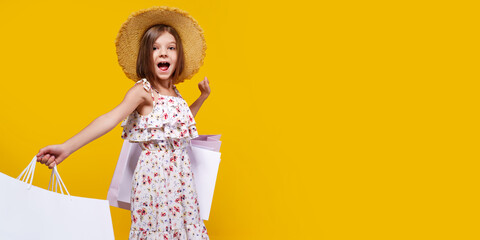Portrait Of Joyful Teen Girl In Straw Hat With Bright Shopping Bags Over Yellow Background