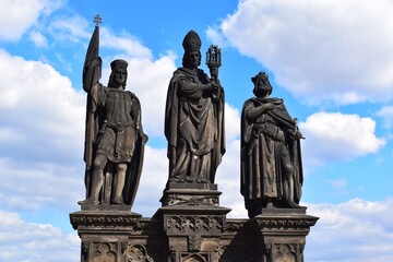 Fototapeta na wymiar The statue of Saints Norbert of Xanten, Wenceslas and Sigismund on the medieval gothic Charles Bridge in Prague built on the 15th century.