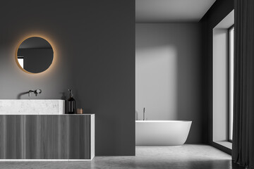 Dark grey bathroom with LED illuminated mirror on partition wall and tub