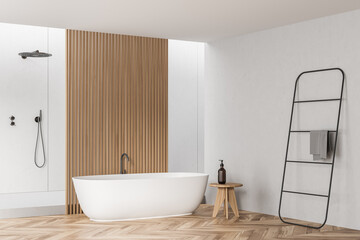 Corner of white bathroom space with wall panelling, ceramic tub and shower